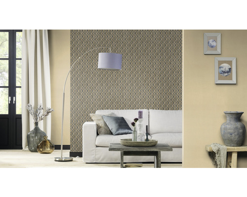 Wohnzimmer mit gemusterter Tapete, Sofa, Stehlampe und dekorativen Elementen für ein gemütliches Ambiente.