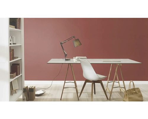 Einrichtungsbeispiel: Schreibtisch mit Lampe und Stuhl in einem Zimmer mit Bücherregal.