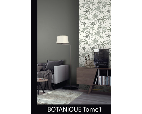 Wohnzimmer mit Sofa, Stehlampe und einer Wand mit Blättermuster-Tapete.