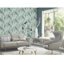 Wohnzimmer mit Sofa, Sessel und Tapete mit Blattmuster