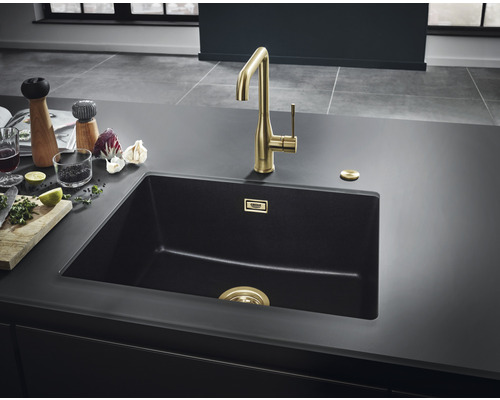 Spültisch mit Armatur und Küchenutensilien auf einer Arbeitsplatte