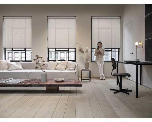 Wohnzimmer mit drei Fenstern und heruntergelassenen Rollos für Sichtschutz und Sonnenschutz