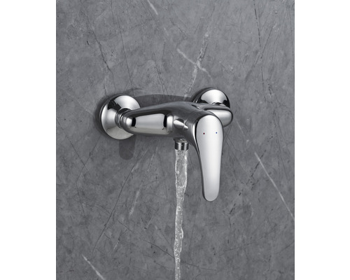 Wandarmatur mit Wasserstrahl vor einer grauen Marmorwand