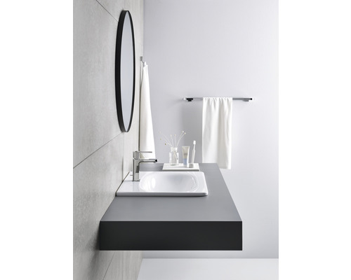 Modernes Badezimmer mit Waschbecken, Armatur, Spiegel und Handtüchern