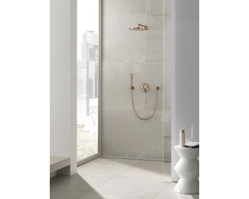 Begehbare Dusche mit Kopfbrause, Handbrause und Armatur in einem hellen Badezimmer