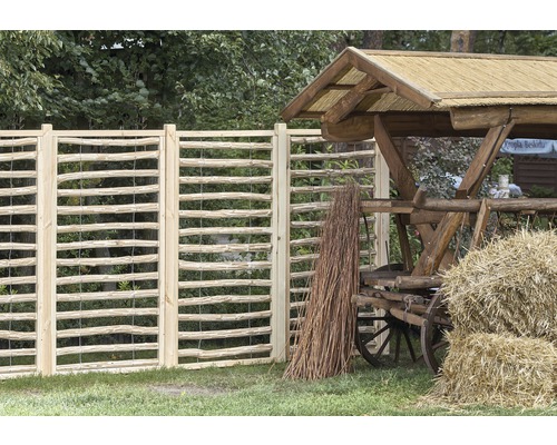 Dekorative Gartenzaun Elemente aus Holz und ein Holzkarren mit Heuballen