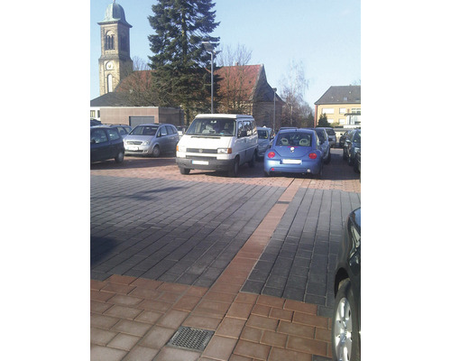 Parkplatz mit gepflasterter Oberfläche und geparkten Autos