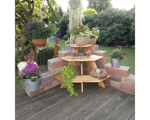 Gestalteter Gartenbereich mit Holzterrasse, Pflanztisch und Blumendekorationen
