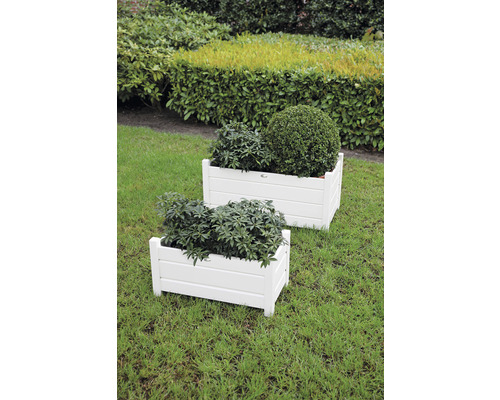 Zwei weiße Pflanzkästen aus Holz auf einer Rasenfläche mit Bepflanzung