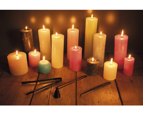 Kerzen in verschiedenen Größen und Farben mit Kerzenlöscher und Dochtschneider auf einem Holztisch