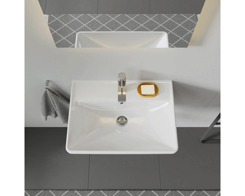 Aufnahme von oben eines Waschbeckens mit Armatur, Seife, Handtuch und Spiegel in einem Badezimmer