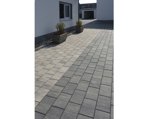 Gepflasterte Auffahrt mit Pflastersteinen und zwei Pflanzkübeln