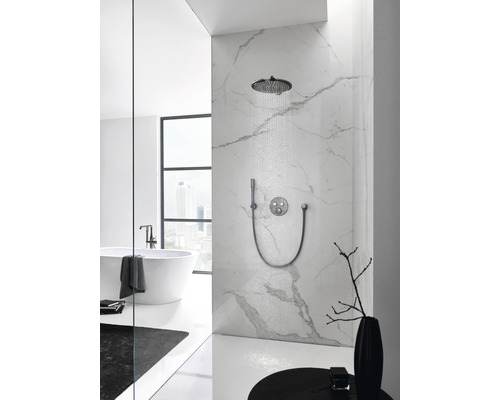 Helles Badezimmer mit Kopfbrause, Handbrause und Armatur an einer Marmorwand.