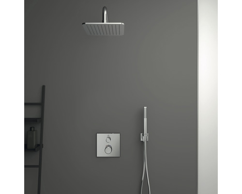 Brausegarnitur mit Kopfbrause, Handbrause und Armatur an grauer Wand