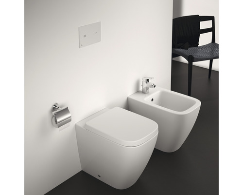 Wandhängendes WC und Bidet in einem Badezimmer mit Toilettenpapierhalter und Spültaste