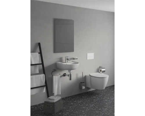 Badezimmer mit Waschbecken, Toilette, Spiegel und Handtüchern