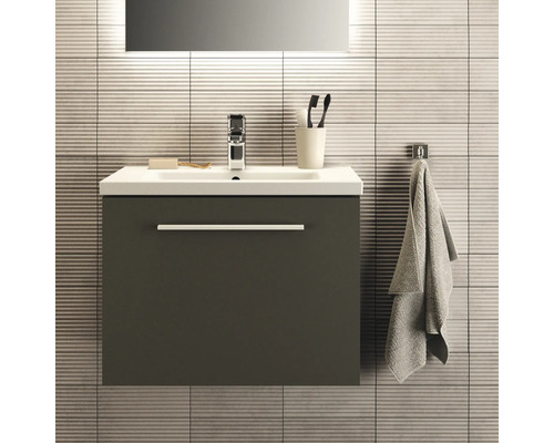 Waschtischunterschrank mit Waschbecken, Armatur, Handtuch und Badaccessoires vor gefliesener Wand