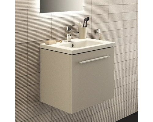 Modernes Badezimmer mit Waschbeckenunterschrank und Armatur vor strukturierter Wand