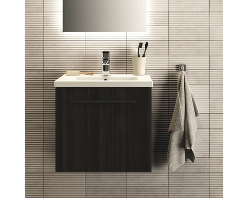 Modernes Badezimmer mit Waschtischunterschrank, Waschbecken, Armatur, Handtuch und Badaccessoires.
