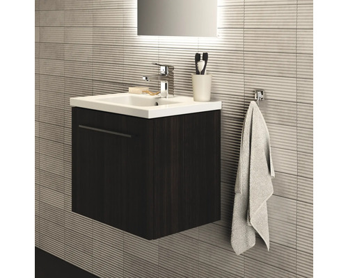 Badezimmer mit Waschtischunterschrank, Waschbecken, Armatur und Handtuchhalter an strukturierter Wand