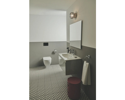 Modernes Badezimmer mit Toilette, Waschbecken, Spiegel und rotem Hocker