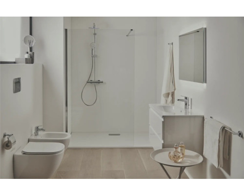 Helles Badezimmer mit Dusche, Toilette, Bidet, Waschbeckenunterschrank und Spiegel