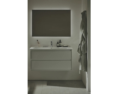 Modernes Badezimmer mit Waschtischunterschrank, Waschbecken, beleuchtetem Spiegel und Bademantel