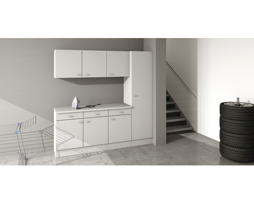 Wäschebereich mit weißen Schränken, Bügeleisen, Wäscheständer und Reifenstapel