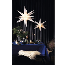 Festlich gedeckter Tisch mit Weihnachtsdekoration und beleuchteten Papiersternen