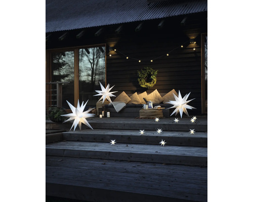 Holzterrasse mit beleuchteten Sternen, Lichterkette und Dekoration für den Aussenbereich