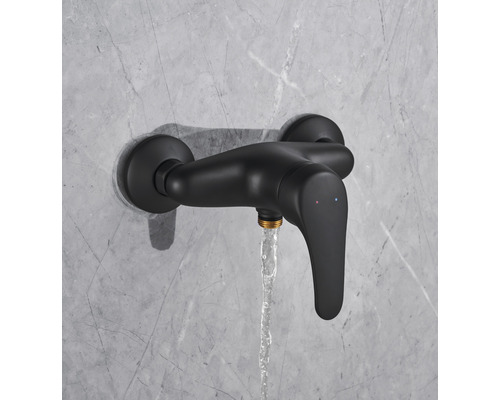 Schwarze Duscharmatur mit laufendem Wasser an einer Wand