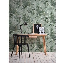 Arbeitszimmer mit Schreibtisch, Stuhl, Schreibtischlampe und tropischer Blättertapete