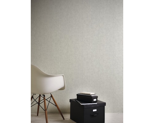 Wohnszene mit hellfarbiger Tapete, weißem Stuhl und schwarzen Aufbewahrungsboxen