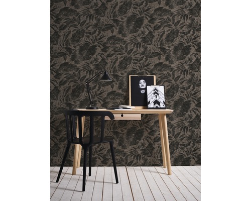 Ein Arbeitszimmer mit einer gemusterten Tapete, einem Schreibtisch, einem Stuhl und einer Schreibtischlampe.