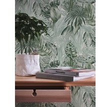 Wandgestaltung mit Tapete im Blätterdesign, Schreibtisch mit Pflanze und Büchern