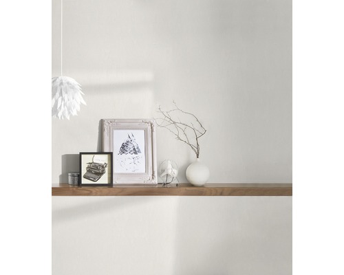 Wohnszene mit Holzregal, Dekorationselementen wie Bilderrahmen, Vase mit Zweigen und Papierleuchte