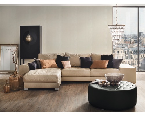 Wohnzimmer mit Ecksofa, Schrank, Ottoman, Kronleuchter und dekorativen Accessoires für ein stilvolles Ambiente
