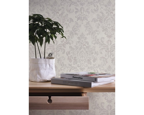 Tapete mit floralem Muster im Interieur mit Tisch, Pflanze und Büchern