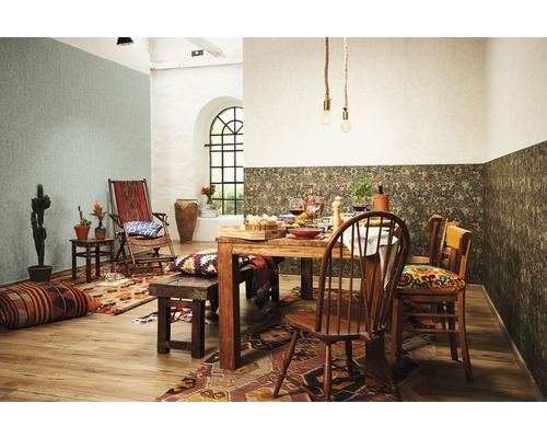 Ein Esszimmer mit Holztisch, Stühlen und dekorativen Elementen wie Kissen, Teppichen und Pflanzen