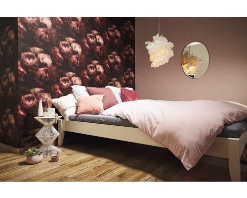 Helles Schlafzimmer mit Bett, Nachttisch und floraler Tapete