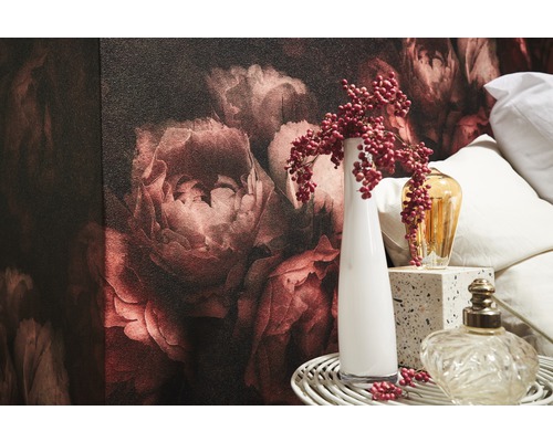 Nahaufnahme eines Raumes mit Blumentapete, Vasen und Dekorationsgegenständen.