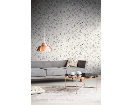 Wohnzimmer mit grauer Couch, Tisch und gemusterter Tapete