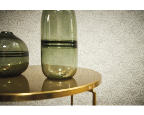 Zwei Glasvasen auf einem Tisch vor einer Wandtapete mit Art-Deco-Muster.