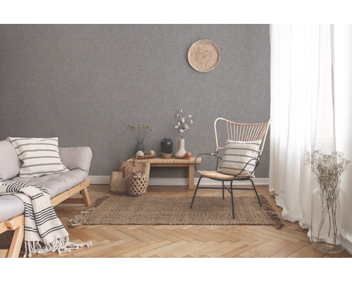 Helles Wohnzimmer mit Sofa, Stuhl, Teppich und grauer Tapete