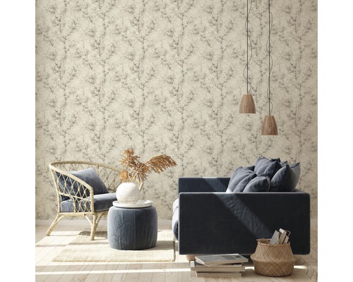 Wohnzimmer mit gemusterter Tapete, Sofa, Sessel und dekorativen Elementen für eine gemütliche Atmosphäre