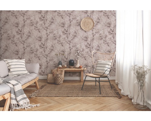 Wohnzimmer mit gemusterter Tapete, Sofa, Sessel und Teppich