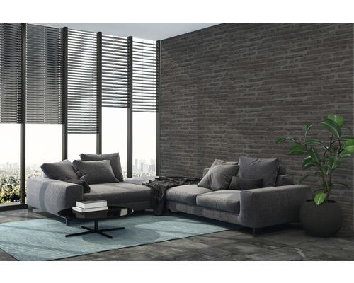 Wohnzimmer mit Ecksofa, Jalousien und Ziegelwand