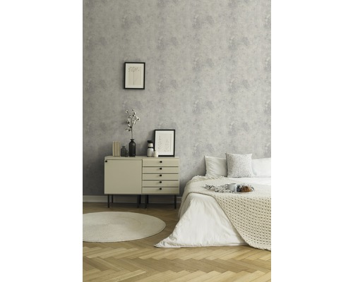 Schlafzimmer mit Bett, Kommode und gemusterter Tapete