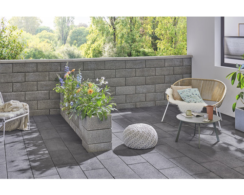 Gestalteter Terrassenbereich mit Mauer, Bepflanzung, Sitzgelegenheiten und Bodenplatten