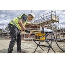 Ein Bauarbeiter bedient eine Tischkreissäge auf einer Baustelle.